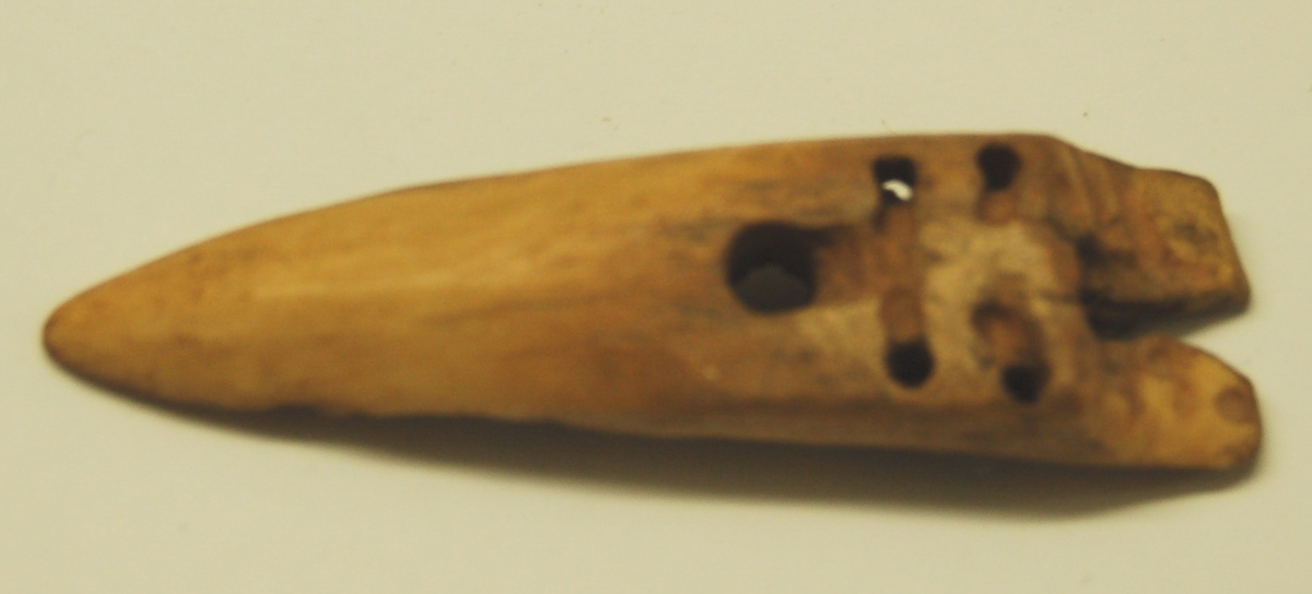 Gjenstanden er utskoren av kvalbein og formet som en spydspiss med to små mothaker i enden. Nederst på spydspissen er der laget hull til festing av linen.