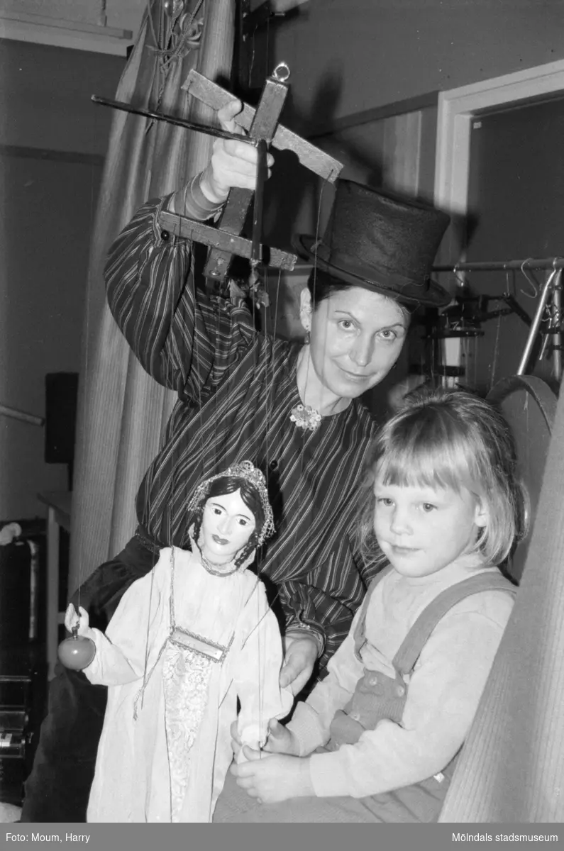 Familjesöndag med diverse aktiviteter på Almåsgården i Lindome, år 1984. "Eliška Recinovà fick hjälp av Anna Erlandsson att ställa i ordning inför marionettföreställningen."

För mer information om bilden se under tilläggsinformation.