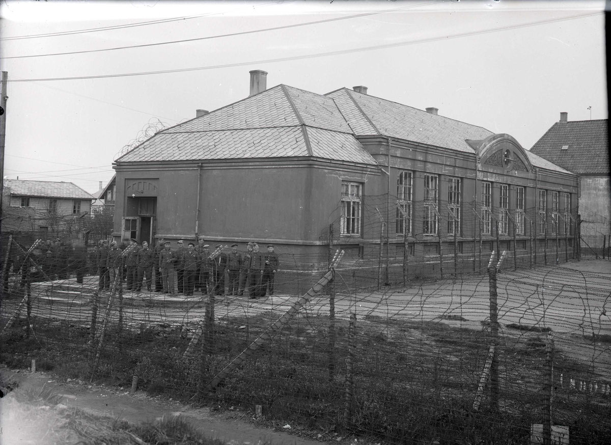 Øst-europeiske krigsfanger bak piggtrådgjerdet på Risøyskolen.
