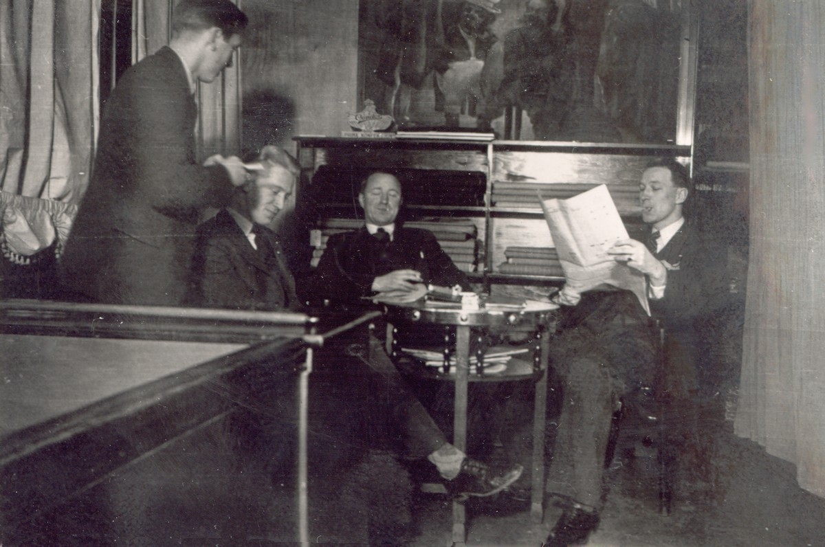 Fire menn rundt et bord på dresslageret