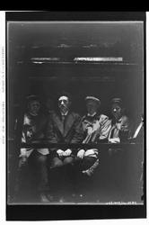 Fire manns personer sitter på en benk ?