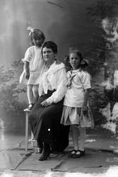 Studioportrett av en kvinne med to unge piker.