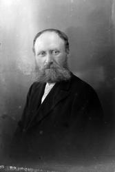 Studioportrett av en mann i halvfigur.