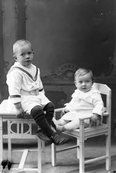 Studioportrett av to barn i helfigur.