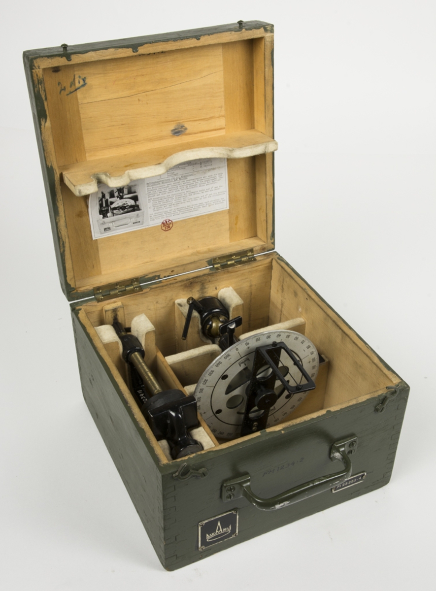 Askania devieringsinstrumentet för kompasser. Förvaras i en grön trälåda. I locket finns en fastklistrad innehållsförteckning och bruksanvisning på tyska. Lådan är försedd med ett bärhandtag. I lådan ligger även fastsättningsanordning.
