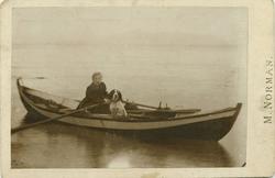 Magdalene Norman i spissbåten "Svalen" med hunden "Frøia". S