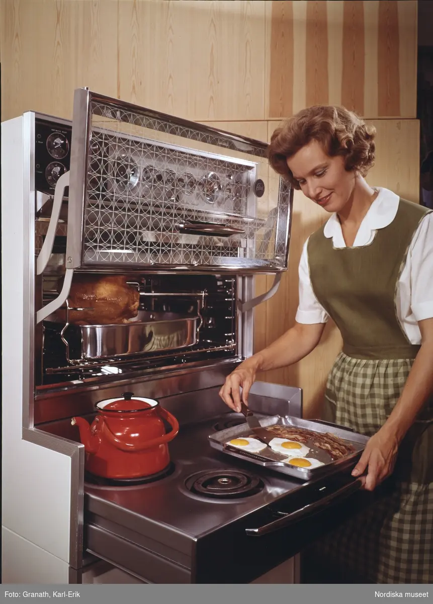 Hushåll. En kvinna steker ägg och bacon.