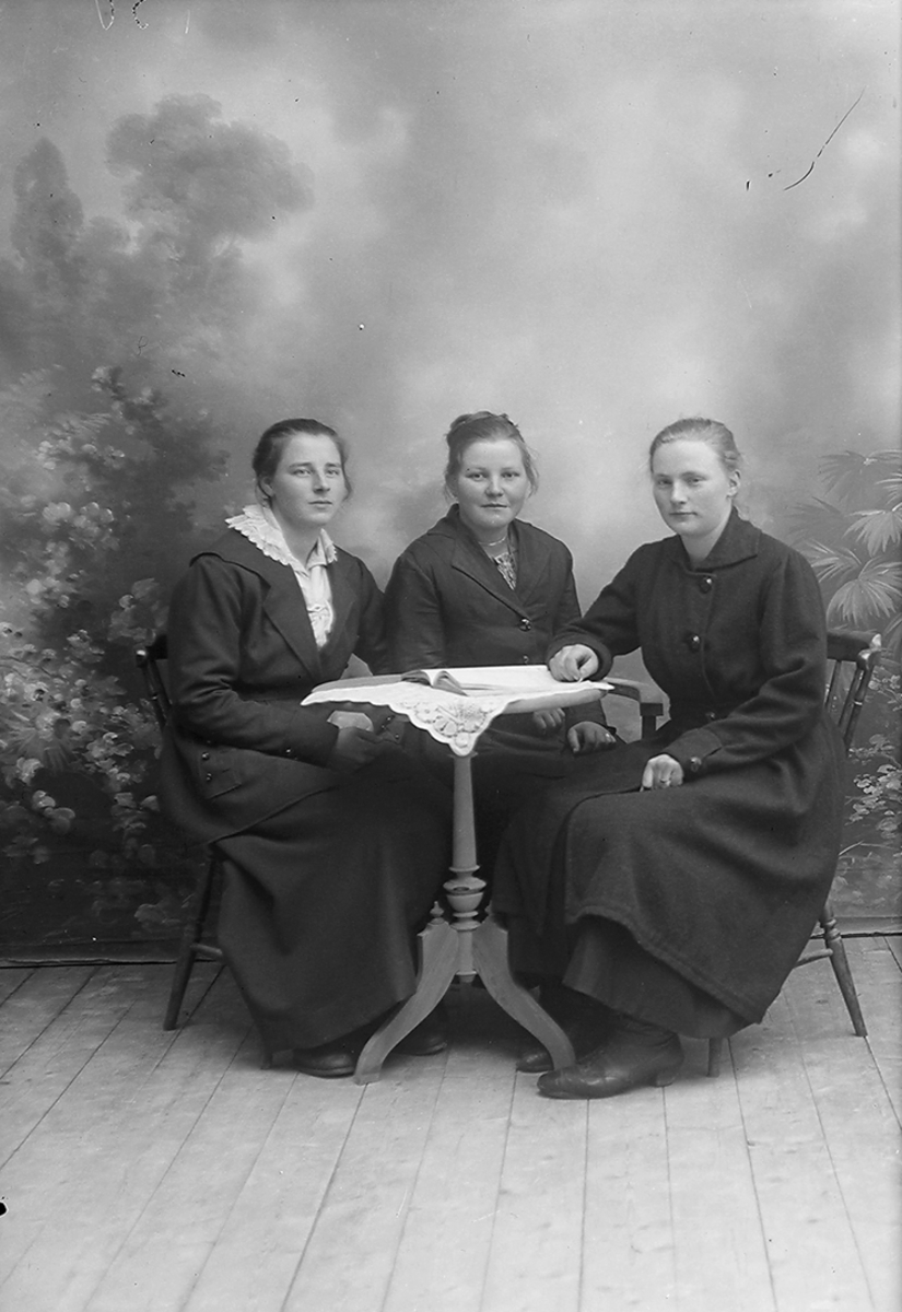 Portrett. Tre damer. Sitter rundt et bord.Fra venstre: Olga Beck,Inndyr, Harda Ingvalda Nikoline Lorntsen,(usikkert), Sørfugløy og Johanna Danielsen, Inndyr.