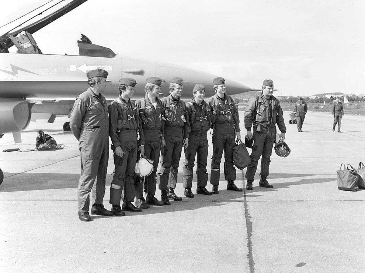 Gruppefoto av 7 personer foran en F-16.