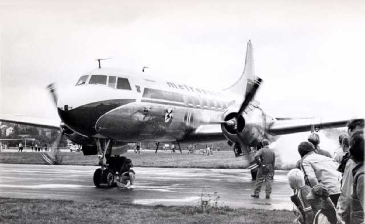 Lufthavn. Et fly på bakken, Convair CV440-75 Metropolitan. Mennesker ved flyet