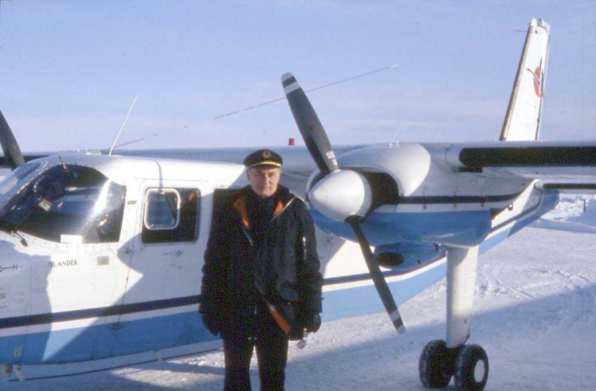 Lufthavn. Ett fly på bakken, Britten-Norman BN-2A-21 Islander, LN-MAG fra Norving. En person, ant. pilot står foran flyet. Snø på bakken.