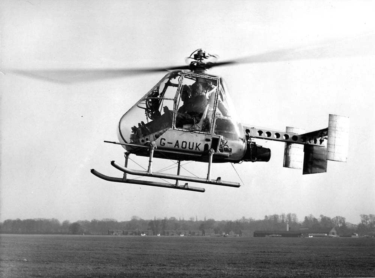 Luftfoto. Ett helikopter i luften like over bakken, Fairey Ultralight Helicopter G-AOUK.