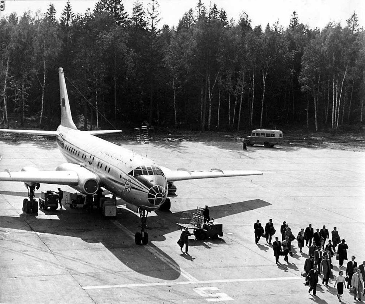 Lufthavn. Ett fly på bakken, Tupolev Tu-104A Camel fra Aeroflot. Flere passasjer på vei fra flyet.