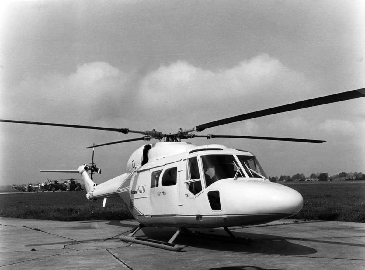 Ett helikopter på bakken. Westland 606 (Lynx). Fire Westland Sea King skimtes t.h bak i bildet, tre tyske og en engelsk.