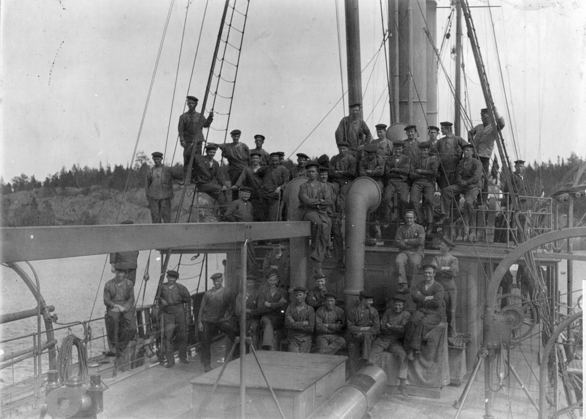 Fartyget Blendas besättning poserar på däck år 1911 under ubåtsskolan. Alla bär tidsenliga sjömanskläder.
