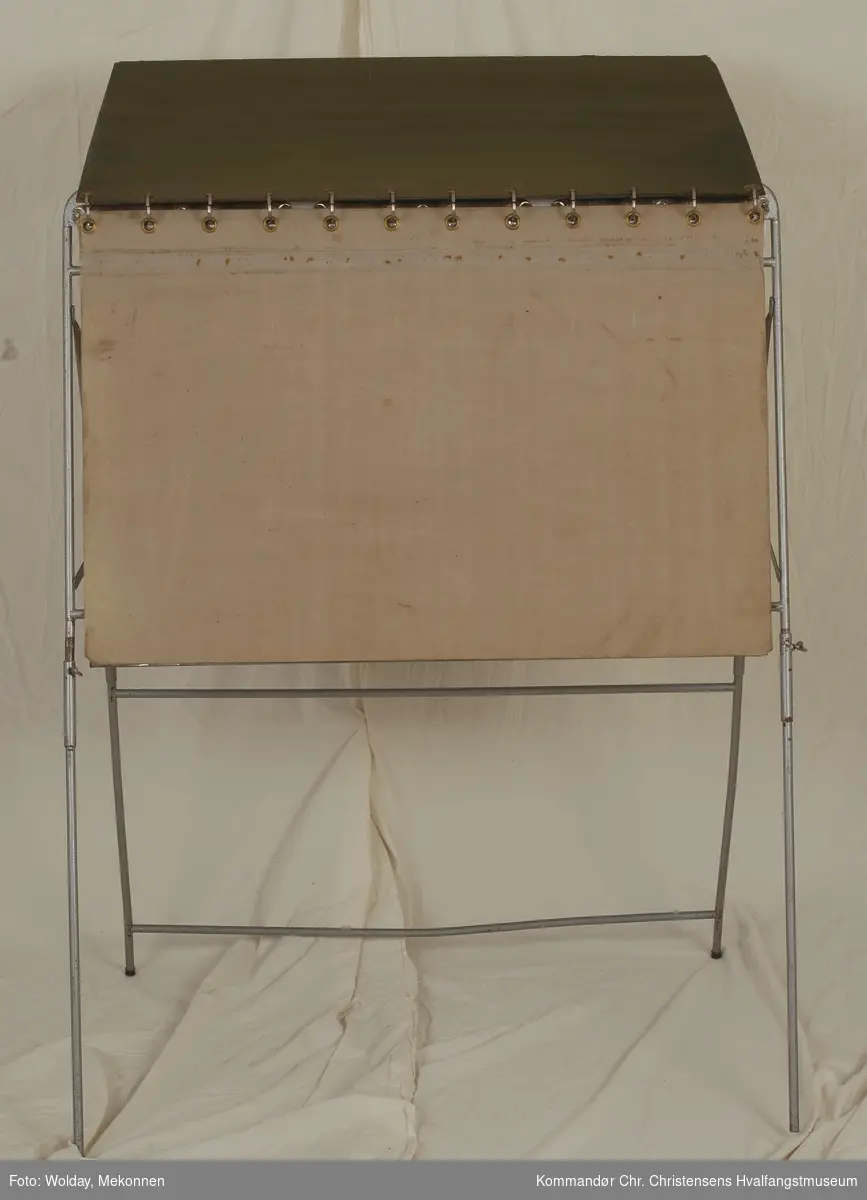 Teknikk: Rektangulær tavle montert på stativ (ringpermprinsipp) Metallplate bak - for magneter? 4 regulerbare bein. Forside av finer/ kartong trukket med lerretsstoff.
Form: Rektangulær
