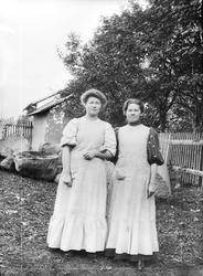 Løten eller Gjøvik. To ukjente kvinner i arbeidstøy, forkle.