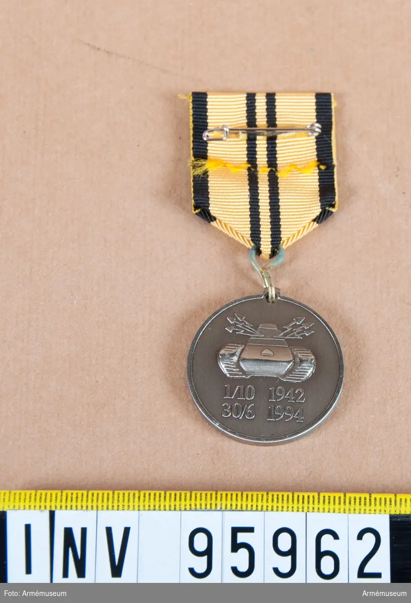Skånska dragonregementets (P 2) minnesmedalj 1 i silver, 8:e storleken.

Band: gult med svarta kanter och två svarta ränder på mitten.