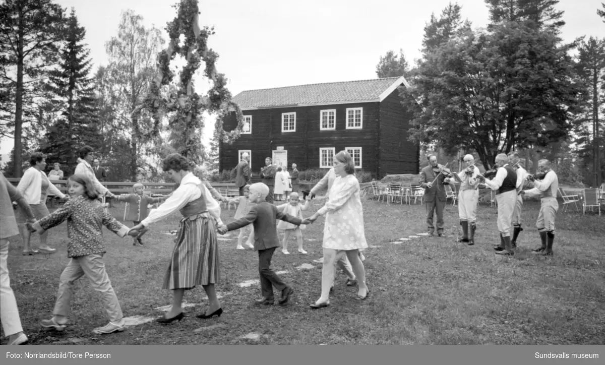 Midsommarfirande på Huberget i Stöde, med spelmän och dans kring midsommarstången.