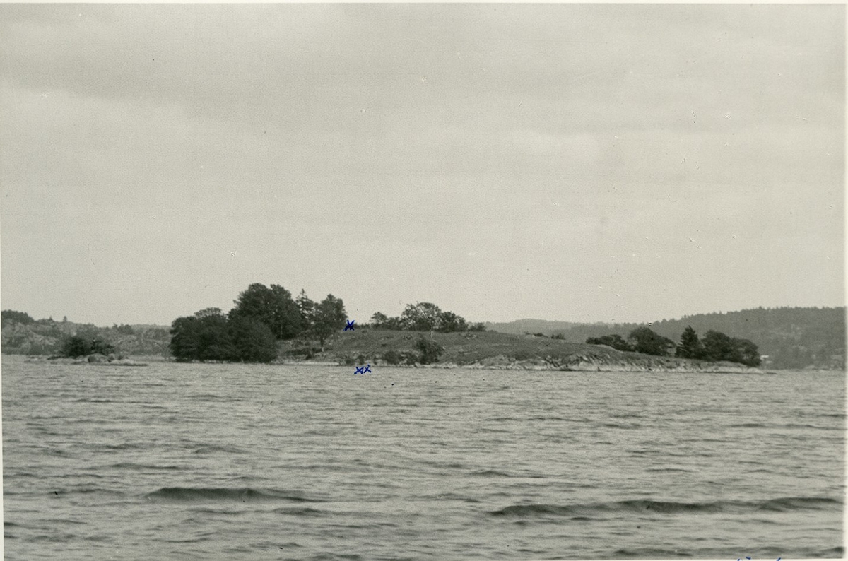 Loholmen i sjön Anten, sedd fr. V. Långared.  Markerat på bilden: x är slottsgrunden, xx rester av bryggan. Den lilla klippön till vänster kallas Idön.