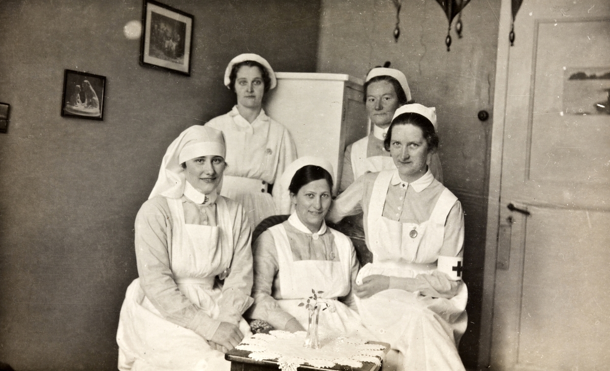 Gruppebilde av fem sykepleiere, fotografert innendørs på Vensmoen tuberkulosesanatorium.