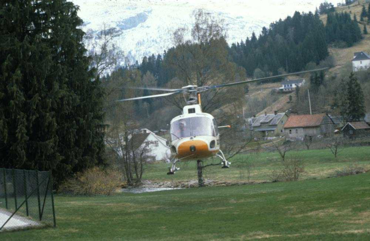 Landskap. Helikopter Aérospatiale AS.350 fra Mørefly tar av for nytt oppdrag.