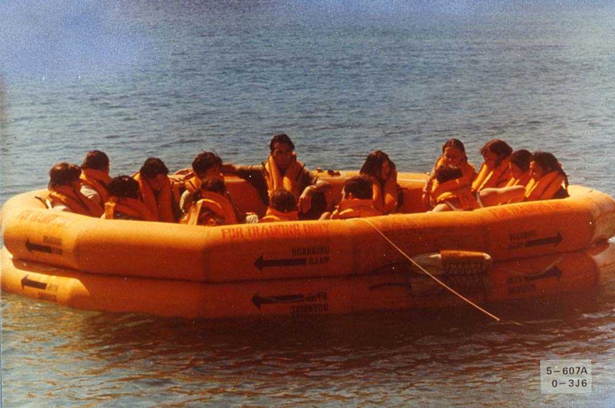Flere personer ombord i en redningsflåte på vannet, for bruk i et fly.