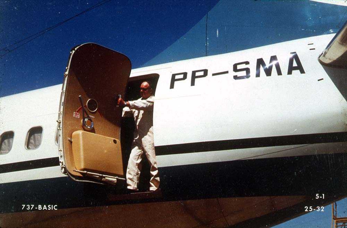 En person som åpner/lukker bakre dør på ett fly, Boeing 737-200 PP-SMA.