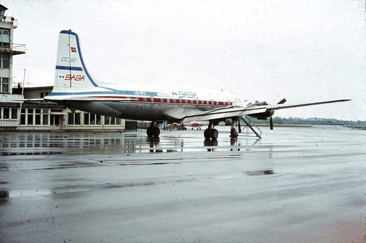 Lufthavn. Ett fly på bakken, Douglas DC-6B Cloudmaster LN-MTU fra SAGA. Bygning i bakgrunnen.