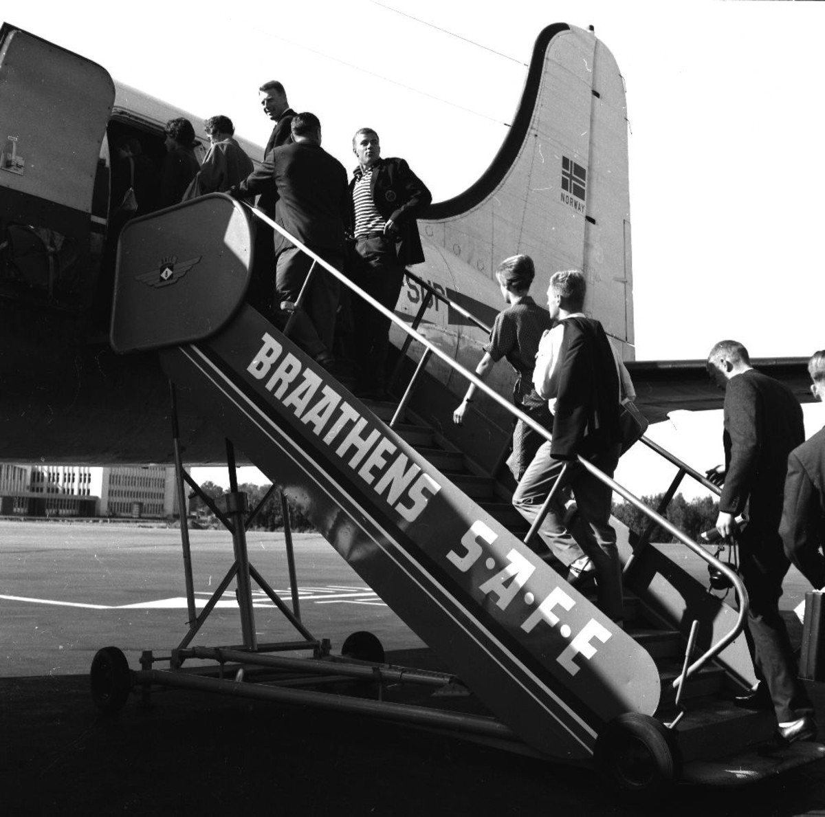 Lufthavn/Flyplass. Et fly, LN-SUP, DC-54B Skymaster,  fra Braathens SAFE tar imot passasjerer. Det er kø opp flytrappa.