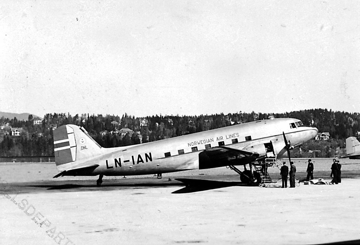 Lufthavn, 1 fly på bakken, Douglas DC-3 C-47A-90-DL, LN-IAN "Nordvind/ Gunnar Viking" fra Staten v/Forsvarsdepartementet. Flere personer ved flyet.