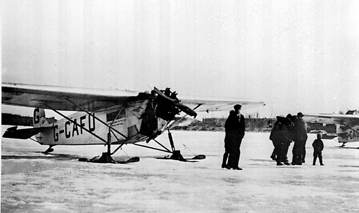 Flere personer ved 1 fly, Fokker Universal, G-CAFU fra Western Canada Airways. 1 annet fly i bakgrunnen.
Bildet tatt ved Hudson Bay airlift i 1927.