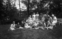 En gruppe mennesker fotografert i en hage