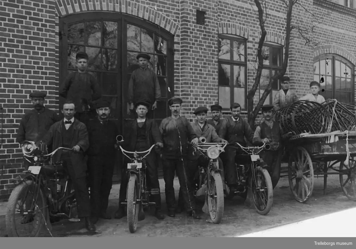 Rosanders arbetsstyrka år 1920. Till vänster nr 2: verkmästare Löfdal. Man stoltserar med fyra motorcyklar och en vagn.