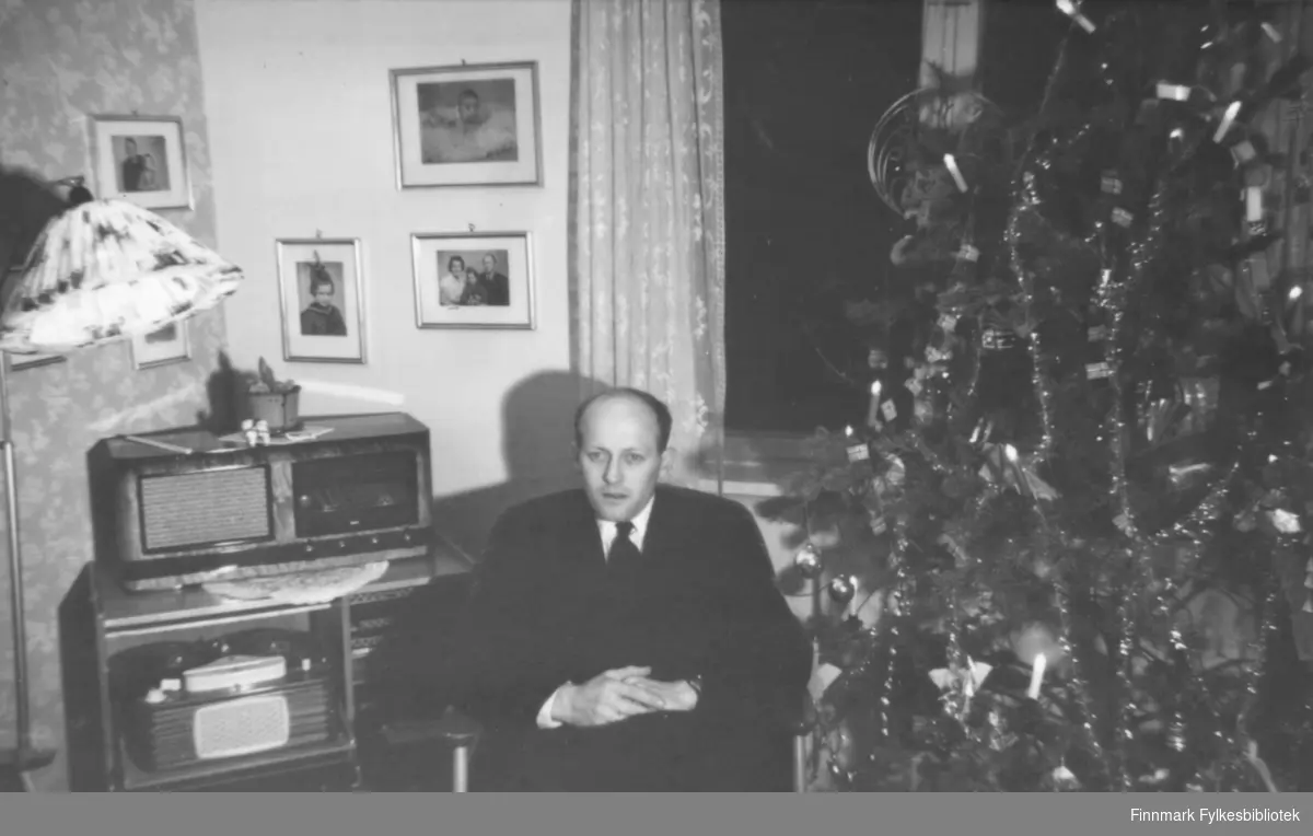 Jul, ca. 1960-1961. Fritz Ebeltoft sitter ved juletreet, i bakgrunnen et radiokabinett med platespiller