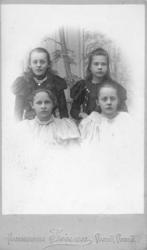 Gruppeportrett av fire jenter. Jenta til venstre øverst er A