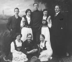 Gruppeportrett av fire menn og fire kvinner tatt i et fotoat