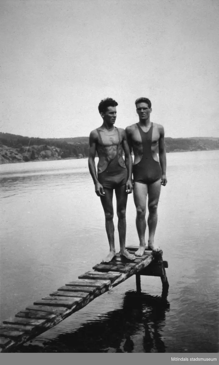 Två baddräktsklädda män poserar ståendes längst ut på en brygga, troligtvis vid Tulebosjön cirka 1930.