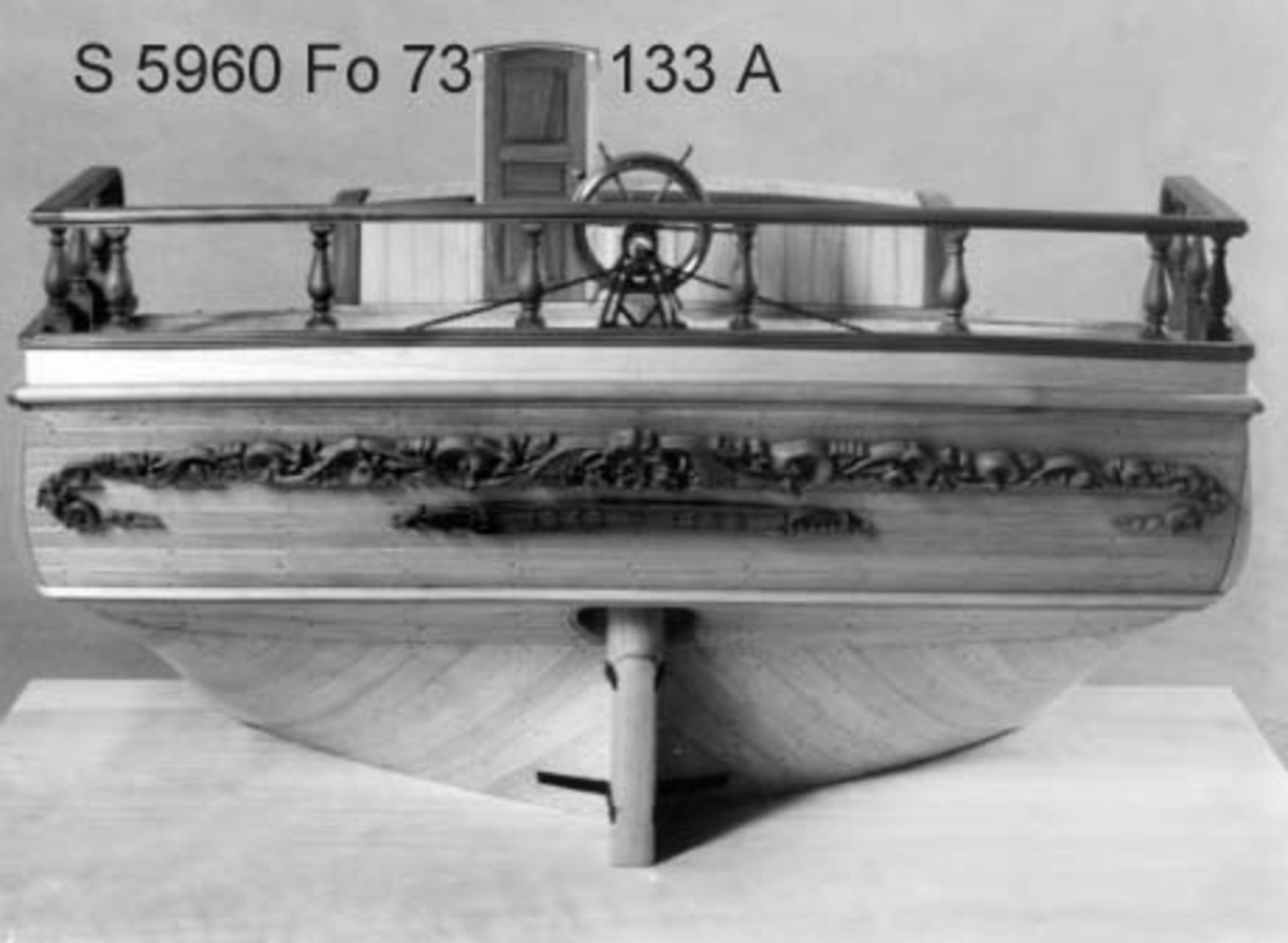 Modell av akterskepp till träsegelfartyg, barkskepp, efter plansch II i Kierkegaard Praktisk Skeppsbyggnadskonst, byggd på klots av al med detaljer och skulptur av päronträ, smiden av oxiderad mässing. Oljad.