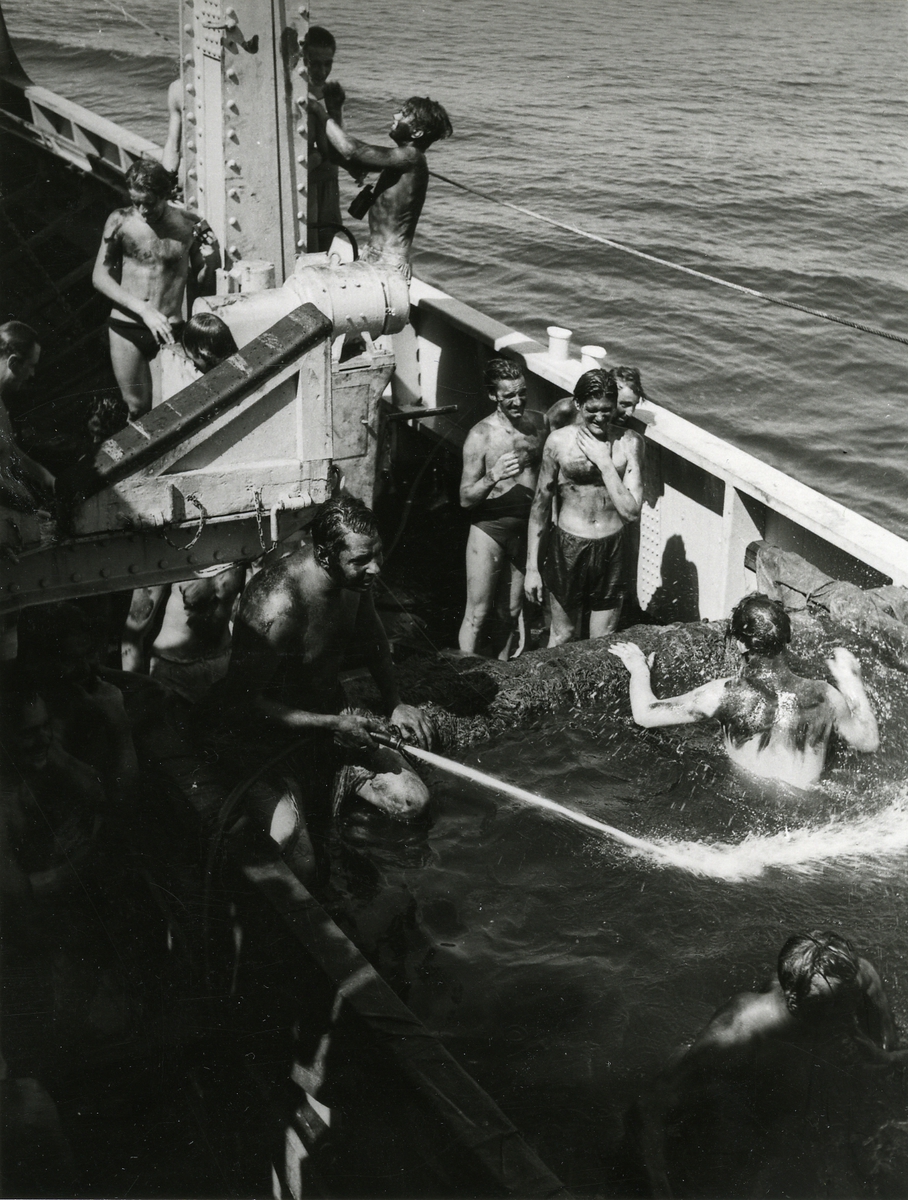 Besättningsmän badar efter att ha arbetat med kol.
