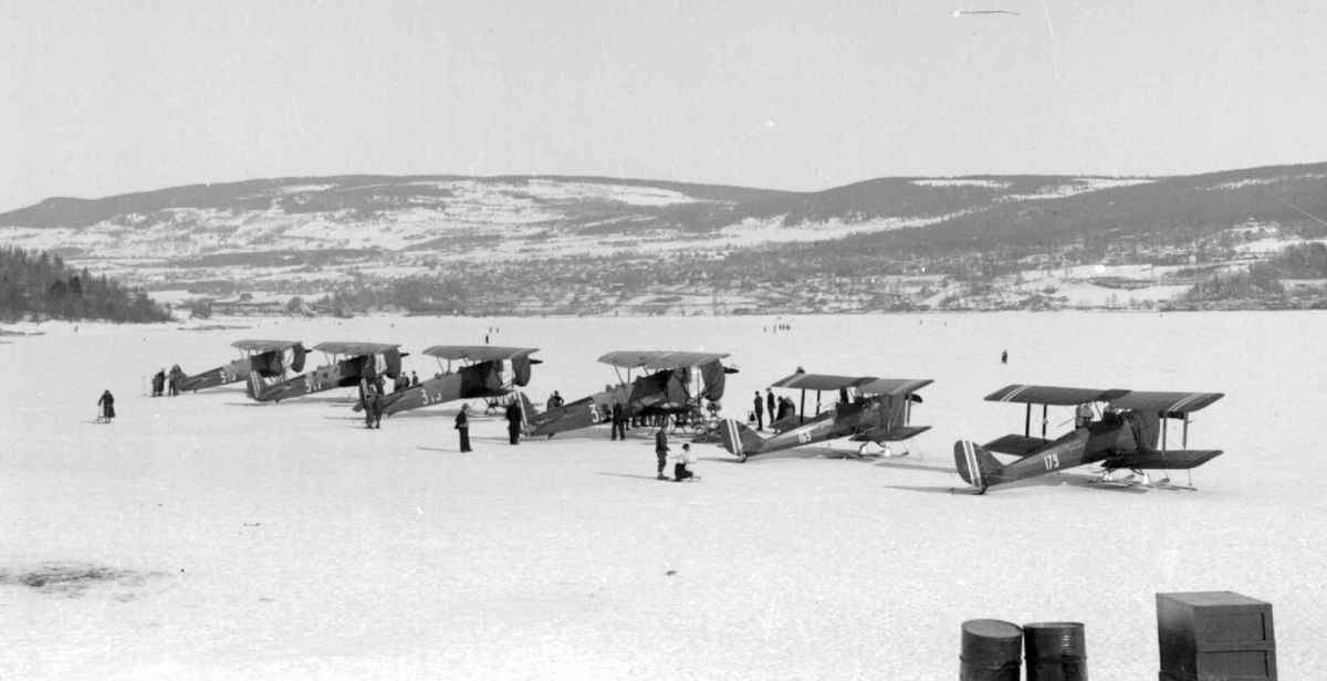 Fly. Hærens fly.  Sju Fokker og Tiger Moth. Blant annet fly 169 og 179. Mjøsisen. Lillehammer by i bakgrunnen.