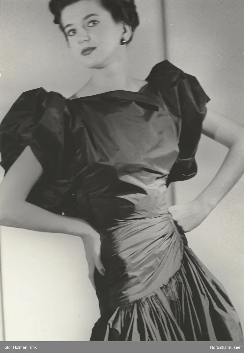 Modell i mörk aftonklänning med puffärmar. Från Madame Grès.