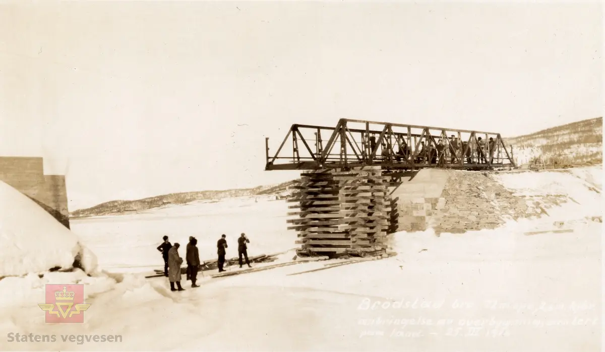 Tekst på bildet: "Brødstad bro, 22 m spv. 2,6 m. kjbr. anbringelse av overbygning, montert på land. - 25. III. 1916". 
Brødstad bru, 22 meter spennvidde, 2,6 meter kjørebredde anbringelse av overbygning, montert på land. 25. mars 1916.