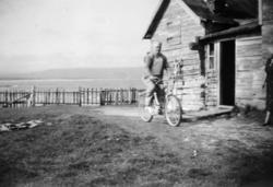 En mann på sykkel utenfor et hus i Nyhamn.