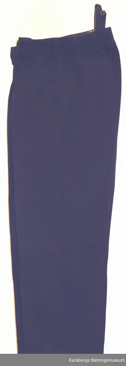 Storlek: 52
Långbyxa m/1930 - tillverkas av mörkblått diagonaltyg. Byxorna har två sidfickor, en bakficka, varav den senare med knapp och knapphål. Byxorna har hällor för livrem och hängslestroppas med knappar.