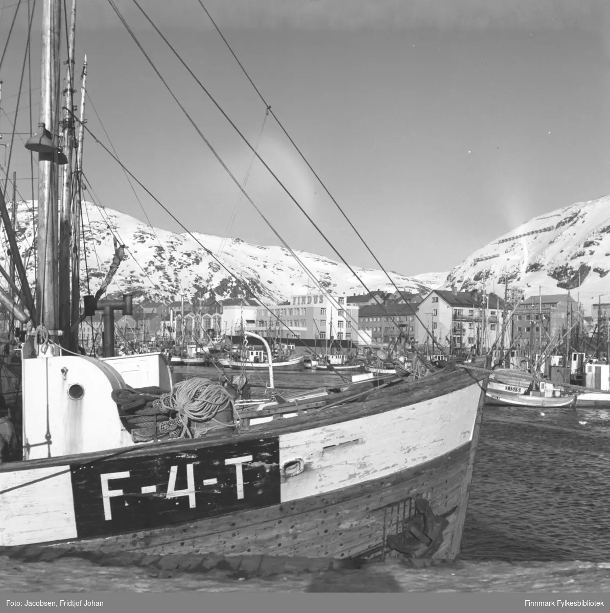 Hammerfest havn med en masse fiskebåter sett fra Nissenkaia. Findus-anlegget ses midt på bildet og fjellet til høyre er Salen.