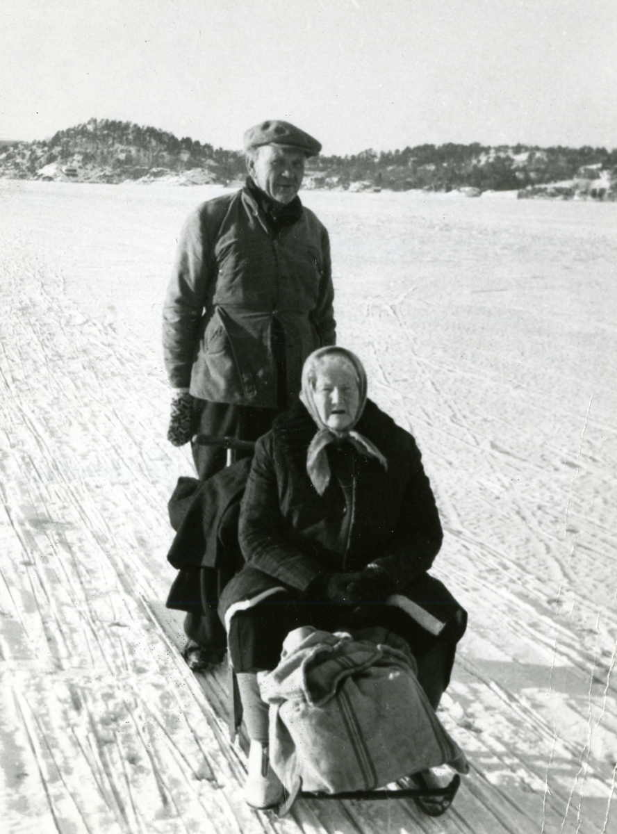 Knut og Anna Larsen sparker over isen med posten. Skåtøysunda, Skåtøy, Kragerø.