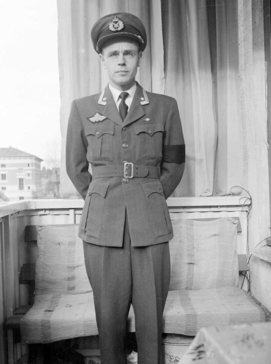 Mann i uniform. Gunnar Berge i flyveruniform - bærer flyvervingen over brystlommen og
med sørgebind på sin venstre arm. På veranda og i Søndre Park.