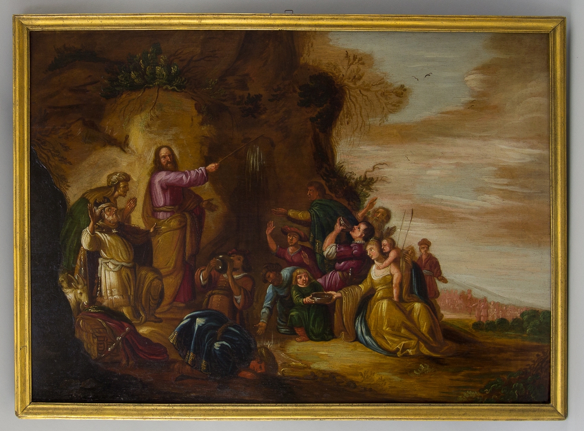 Biblisk scen, Moses slår vatten ur klippan (2 Mosebok 17:1-17). Moses står med käppen vid en klippa och män, kvinnor och barn dricker vatten från klippan. I bakgrunden klipplandskap och himmel.