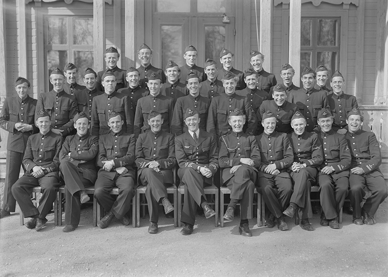 Elever vid furirskolan för flygplansmekaniker på F 3 Östgöta flygflottilj, 1947. 32 stycken elever. Grupporträtt framför byggnad. 2 bilder.